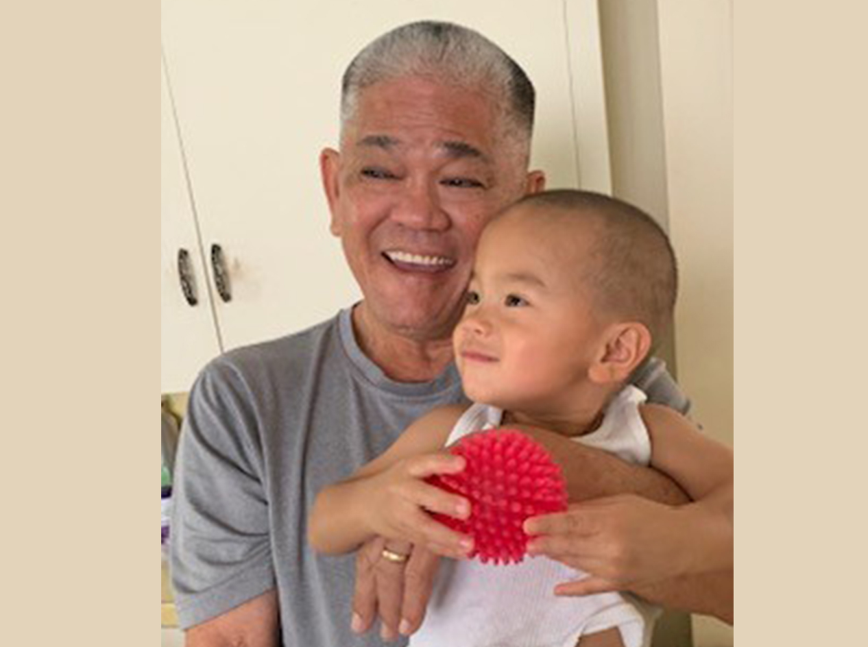 Clifford holding his young grandchild on his lap.