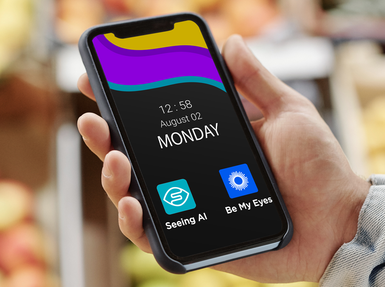 Hand holding cellphone showing the apps Seeing AI and Be My Eyes