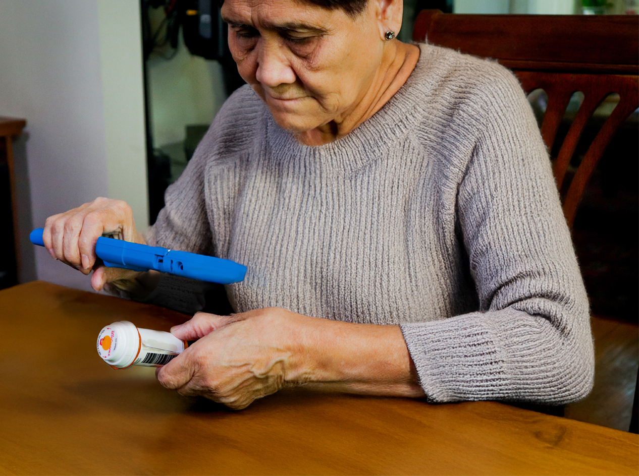 Woman holding video magnifier to read a pill bottle label.