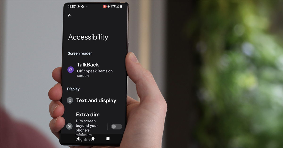 Hand holding Android phone with accessibility settings displayed