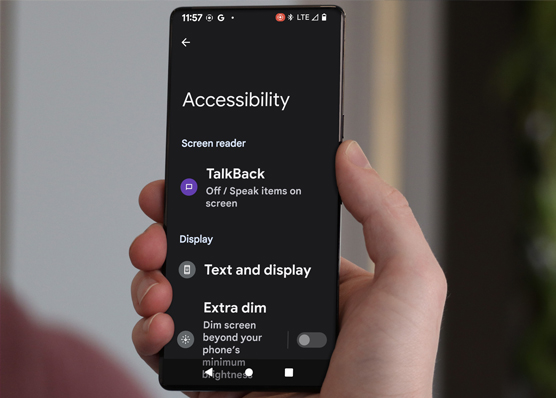 Hand holding Android phone with accessibility settings displayed