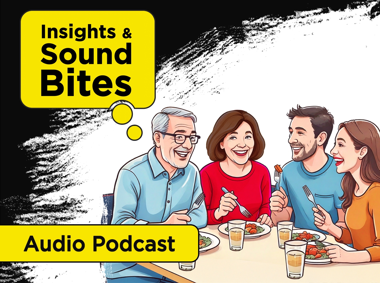 Family of four—middle-aged parents and adult son and daughter—seated around a dinner table eating, sharing stories, and laughing.
