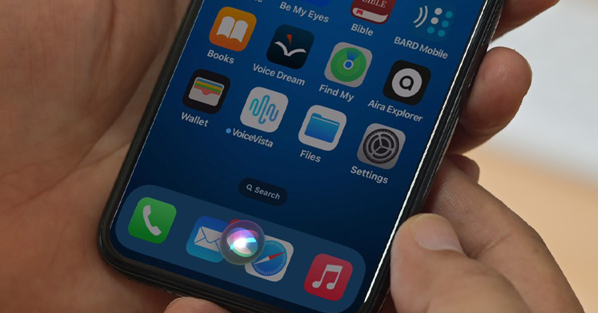 Hand holding smartphone with Siri activated