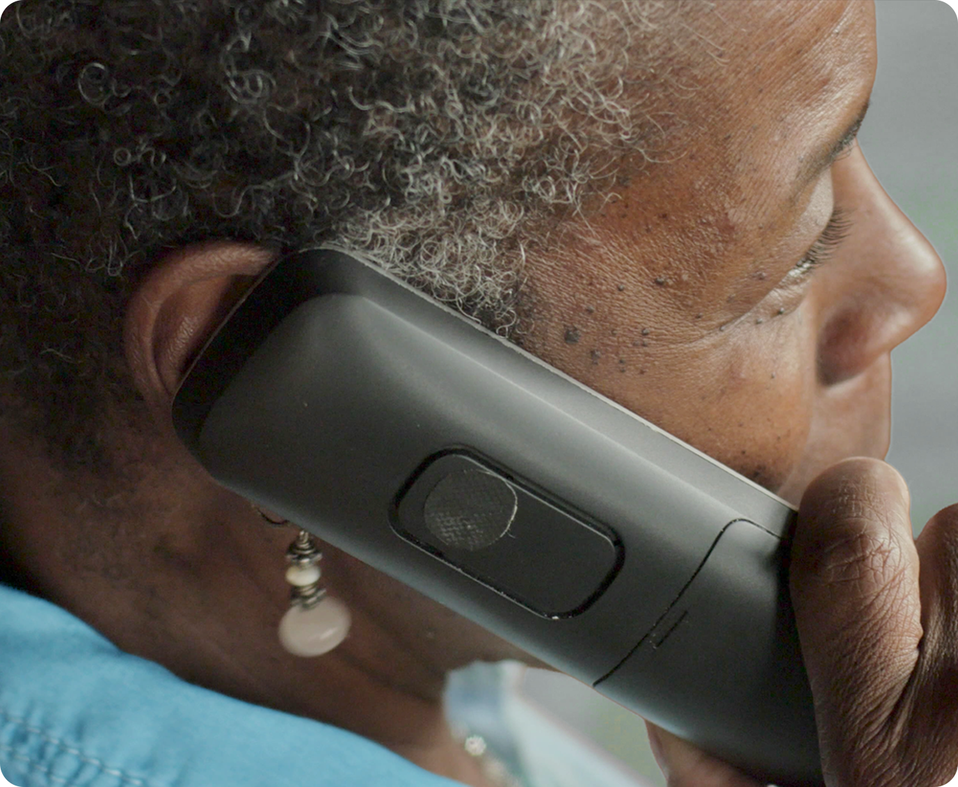 An older adult speaking on the phone, representing peer-to-peer support and connection